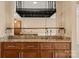 Custom wet bar featuring a stainless steel sink, granite countertops, custom shelving, and wood cabinets at 9801 Emerald Point Dr # 2, Charlotte, NC 28278