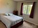 Cozy bedroom features a window view, neutral walls and carpeted floors at 11121 S Harrowfield Rd, Charlotte, NC 28226