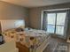 Comfortable bedroom with a large window with patterned drapes and carpet at 11121 S Harrowfield Rd, Charlotte, NC 28226