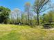 Expansive backyard featuring a lush lawn, mature trees, storage shed, and outdoor dining area on a concrete patio at 1160 Nw 11Th Street Cir, Hickory, NC 28601