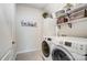 Bright laundry room with white cabinets, shelves, and a washer and dryer at 14207 Asbury Park Rd, Huntersville, NC 28078