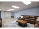 Finished basement with brown leather sectional and concrete floor at 176 Butch Branch Rd, Union Grove, NC 28689