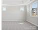 Bedroom with recessed ceiling, large windows, and neutral carpeting at 224 Windy Dell Dr, Tega Cay, SC 29708