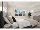 Well-lit primary bedroom showcasing tray ceilings, a large window view, and neutral decor with a dresser and bedside table at 224 Windy Dell Dr, Tega Cay, SC 29708