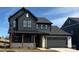 Modern two-story home featuring dark siding, stone accents, a covered porch, and an attached two-car garage at 224 Windy Dell Dr, Tega Cay, SC 29708