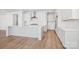 Open kitchen featuring a large island, stainless appliances, white cabinetry, and hardwood floors at 224 Windy Dell Dr, Tega Cay, SC 29708