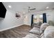 Cozy living room showcasing wood floors, a ceiling fan, a comfortable sofa, and natural light from the windows at 2752 Peachtree Rd, Statesville, NC 28625