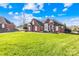 Charming brick home boasts a well-manicured lawn and lovely architectural details under a bright blue sky at 311 Kaitlyn Ln, Kings Mountain, NC 28086