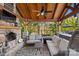 Inviting covered patio with a stone fireplace, comfortable seating, and outdoor fan at 311 Kaitlyn Ln, Kings Mountain, NC 28086