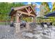 Covered patio with a stone fireplace, bar seating, and outdoor lighting at 311 Kaitlyn Ln, Kings Mountain, NC 28086