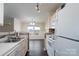 Kitchen with white cabinets, stainless steel sink, and stove at 3809 Carl Parmer Dr, Harrisburg, NC 28075