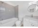This bathroom features a tub, a grey tiled shower, gray walls, and white cabinets at 421 Delburg Mill Alley Dr, Davidson, NC 28036