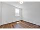 Simple bedroom with wood floors, neutral paint, and a bright window for natural light at 421 Delburg Mill Alley Dr, Davidson, NC 28036