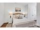 This bedroom features a comfy bed, wood floors, lamps, and a neutral color scheme with art at 421 Delburg Mill Alley Dr, Davidson, NC 28036