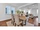 Bright dining room featuring hardwood floors, light-colored walls, and an adjacent living room with modern decor at 421 Delburg Mill Alley Dr, Davidson, NC 28036
