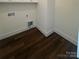 Small laundry room featuring dark hardwood floors and white walls at 421 Delburg Mill Alley Dr, Davidson, NC 28036