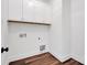 This laundry room features white cabinets, white walls, dark wood floors and convenient utility connections at 421 Delburg Mill Alley Dr, Davidson, NC 28036