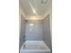 Shower with gray tiled walls, a shower head, and a white tub at 421 Delburg Mill Alley Dr, Davidson, NC 28036