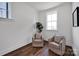Small sitting room with hardwood floors, neutral walls, a large window, and comfortable seating for two at 421 Delburg Mill Alley Dr, Davidson, NC 28036