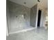 Elegant bathroom with marble-patterned tile walls, built-in shelving, and a sleek, curbless shower design at 426 Richards Ln, Mooresville, NC 28115