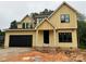 Charming yellow two-story home with black garage door and black-trimmed windows under a cloudy sky at 426 Richards Ln, Mooresville, NC 28115