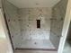 Tiled shower featuring gray stone walls, mosaic tile floor, and a shower niche at 426 Richards Ln, Mooresville, NC 28115