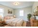 Cozy bedroom with a comfortable bed, two windows and light green walls at 4926 Nc Highway 109 South, Mount Gilead, NC 27306