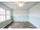 Spacious bedroom with wood-look floors, large windows, and a modern ceiling fan fixture at 4926 Nc Highway 109 South, Mount Gilead, NC 27306