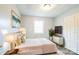 Bright bedroom featuring a queen bed, accent wall art, and a modern dresser with a mounted TV at 4926 Nc Highway 109 South, Mount Gilead, NC 27306
