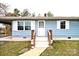 Close-up view of the home's entrance, with its wooden railing, white trim, and freshly painted blue siding at 4926 Nc Highway 109 South, Mount Gilead, NC 27306