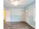 Bright living room featuring wood-look floors, an entry door, and two interior access doors at 4926 Nc Highway 109 South, Mount Gilead, NC 27306
