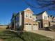 Modern two-story townhome with stone and siding accents, two-car garage, and landscaped lawn at 5860 Clan Maclaine Dr, Charlotte, NC 28278