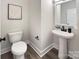 Modern bathroom with pedestal sink, white toilet, and dark accents at 710 N Cedar St, Lincolnton, NC 28092