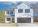 Two-story farmhouse style home with dark brown accents and landscaping at 710 N Cedar St, Lincolnton, NC 28092