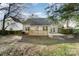 Backyard with gray siding, deck and landscaping, and mature trees at 8624 Woodcock Ln, Charlotte, NC 28216