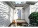 Inviting home entrance with light-colored siding, grey front door with sidelights, and decorative stone landscaping at 8624 Woodcock Ln, Charlotte, NC 28216