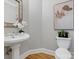 Powder room with pedestal sink and hardwood floor at 10607 Newberry Park Ln, Charlotte, NC 28277