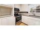 View of kitchen stove, cabinets, granite countertops, and sink at 107 E Boyd St, Maiden, NC 28650