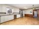 Open kitchen with white cabinets, stainless steel appliances, and cork flooring at 107 E Boyd St, Maiden, NC 28650