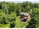 An aerial of the home with fenced yard and spacious deck, surrounded by mature trees at 254 Streamside Pl, Mooresville, NC 28115