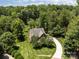 Aerial view of a beautiful brick home nestled among lush trees with a winding driveway at 254 Streamside Pl, Mooresville, NC 28115
