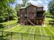 Spacious backyard with a brick home featuring a large deck, patio, and fenced yard at 254 Streamside Pl, Mooresville, NC 28115
