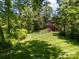 Expansive backyard showcasing lush greenery and the rear of a charming brick home at 254 Streamside Pl, Mooresville, NC 28115