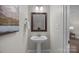 Small bathroom with pedestal sink and framed mirror at 254 Streamside Pl, Mooresville, NC 28115