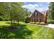 Well-maintained brick home with lush green lawn and mature trees in a serene setting at 254 Streamside Pl, Mooresville, NC 28115