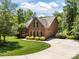 Beautiful brick home with a well-manicured lawn, mature landscaping, and an attached garage at 254 Streamside Pl, Mooresville, NC 28115