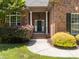 Inviting front entrance with a brick facade, white columns, and a charming black door at 254 Streamside Pl, Mooresville, NC 28115