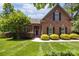 Charming red brick home featuring a beautifully landscaped front yard and classic black shutters at 254 Streamside Pl, Mooresville, NC 28115