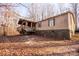 Single-wide mobile home with stone foundation and covered porch, nestled in a wooded setting at 338 Piney Grove Rd, Harmony, NC 28634