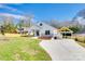 Inviting single-story home with white siding, stone accents, and a detached carport on a lush lawn at 502 Rhyne Cir, Gastonia, NC 28054